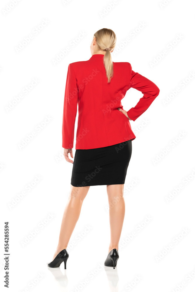 Middle aged senior business woman in red jacket and black skirt posing on white background. Back, rear view. Middle aged senior business woman in red jacket and black skirt posing on white background. Back, rear view.