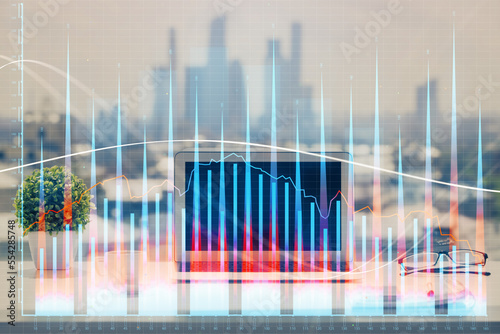 Stock market graph on background with desk and personal computer. Double exposure. Concept of financial analysis.