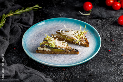Konstfotografi sprats on black bread on dark table