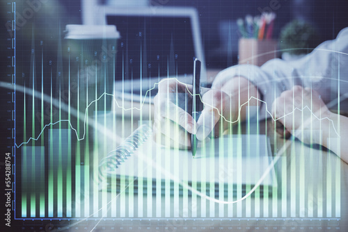 Forex chart displayed on woman's hand taking notes background. Concept of research. Double exposure © peshkova