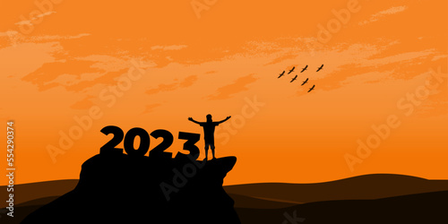 New Year 2023 concept. Man meets dawn in mountains for new year 2023. New Start motivation inspirational quote message on silhouette man