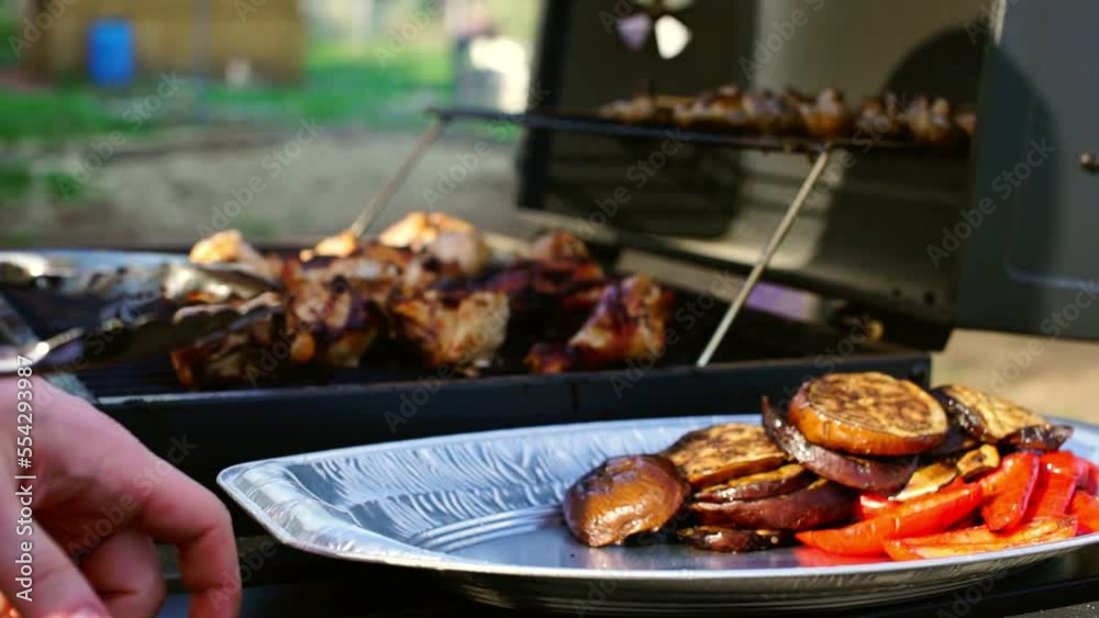 cook fries juicy cuts of chicken meat and chicken legs with vegetables on the grill barbecue in the summer in the open air