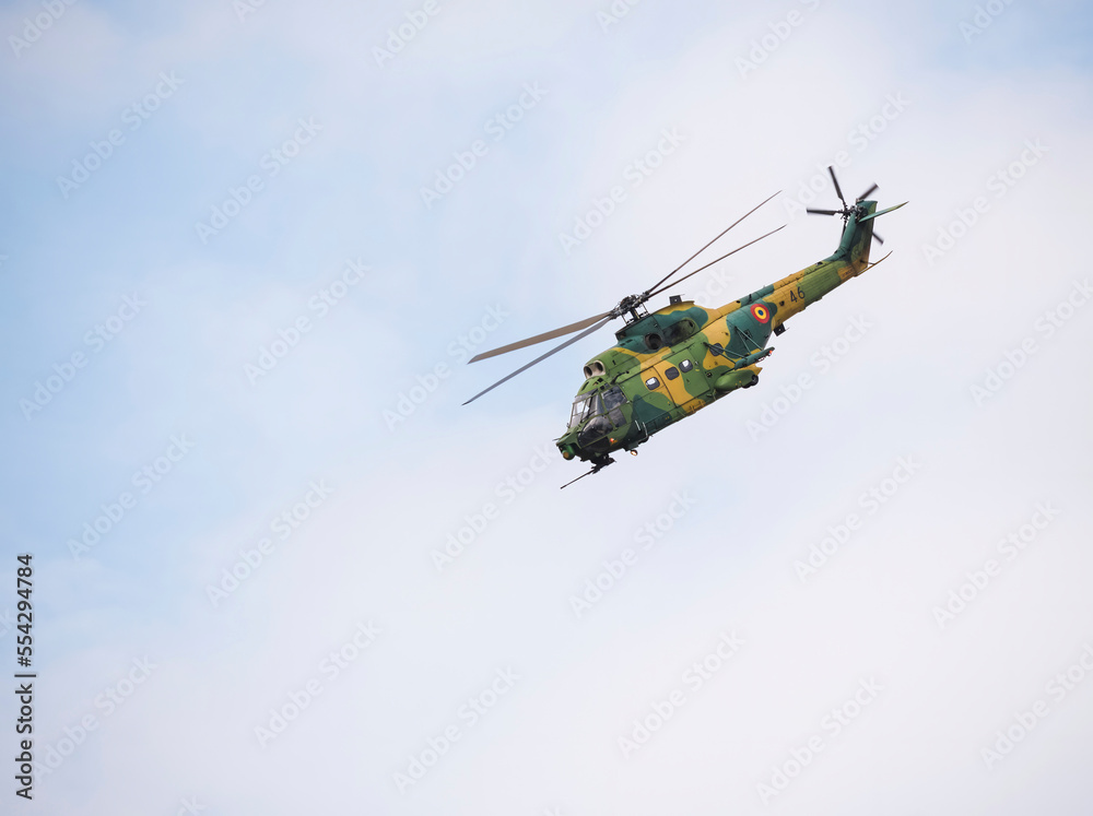 Fototapeta premium Romanian Air Force military and utility IAR 330 helicopter against blue sky.