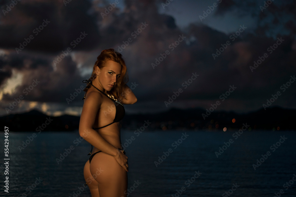 Obraz premium Young beautiful fit sexy female model pose in micro bikini at Pigeon Island, Gross Islet Saint Lucia beach at sunrise