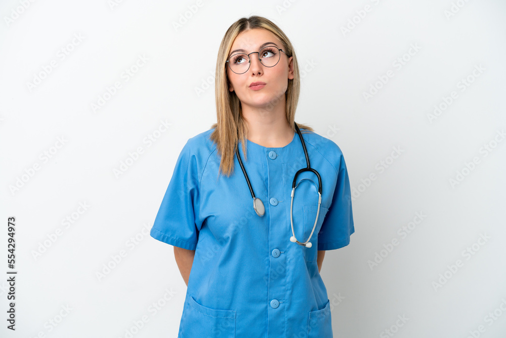 Young surgeon doctor woman isolated on white background and looking up Young surgeon doctor woman isolated on white background and looking up