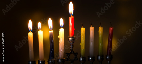Silver Hanukkah menorah with candles on a dark background. Holiday concept