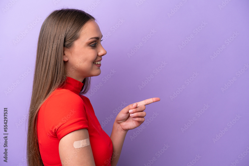 Young caucasian woman wearing band aid isolated on purple background pointing to the side to present a product Young caucasian woman wearing band aid isolated on purple background pointing to the side to present a product