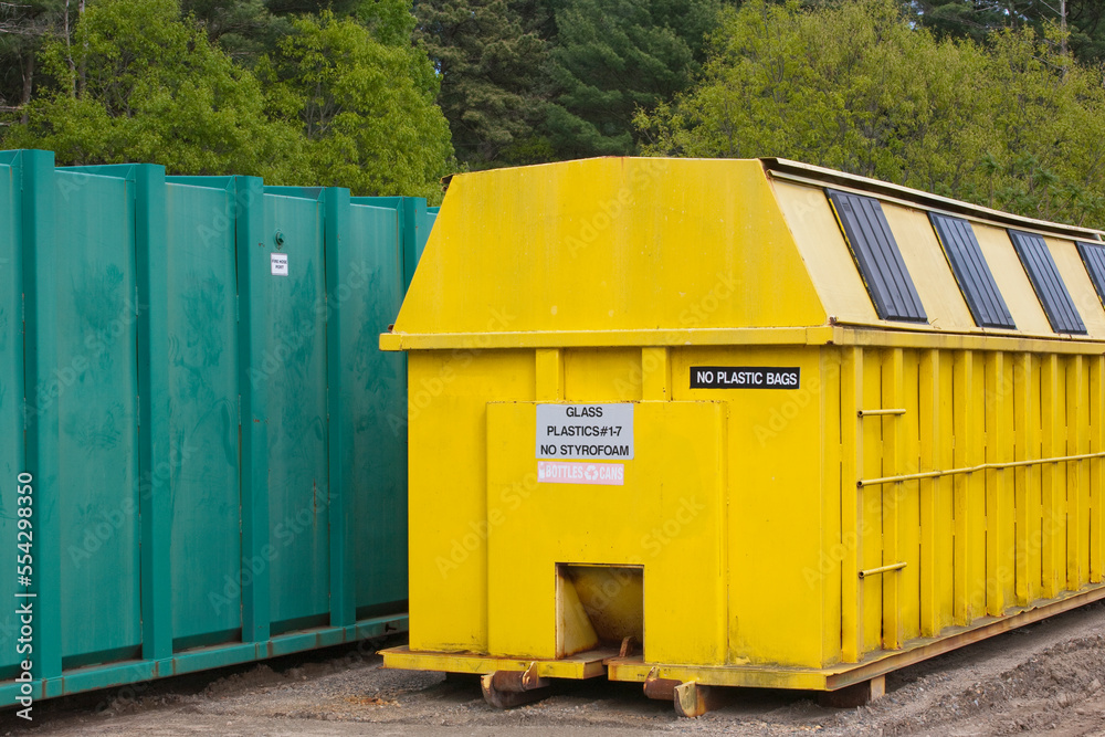 Recycling container used for plastic and glass near a trash container Recycling container used for plastic and glass near a trash container