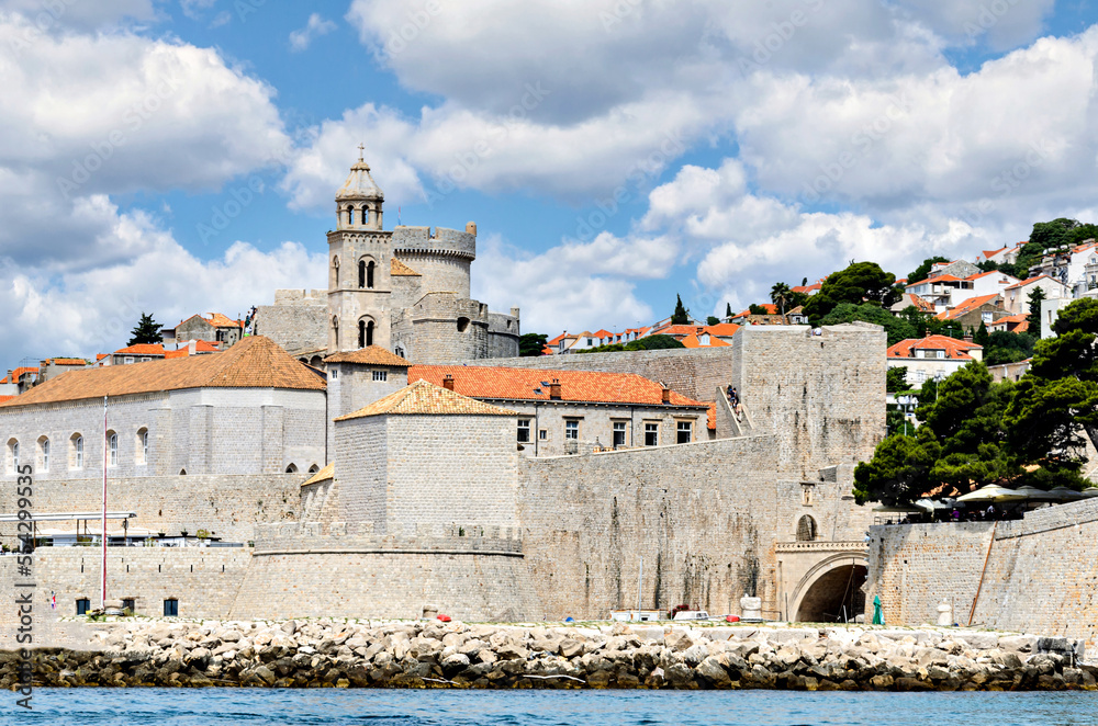 View of the old town of Dubrovnik behind its walls under a blue sky with white clouds, Croatia