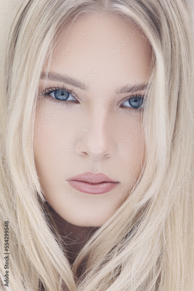 Young woman with straight blonde hair, blue eyes, clear skin with natural make up, poses against a white backdrop. Young woman with straight blonde hair, blue eyes, clear skin with natural make up, poses against a white backdrop.