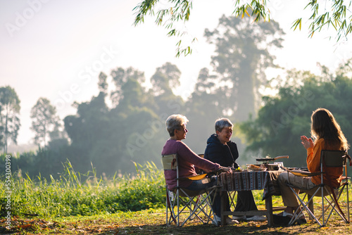 woman family having fun with food of picnic camp in the nature morning, summer travel vacation lifestyle of mother and girl at adventure forest park landscape in holiday, outdoors activity breakfast