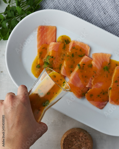Peruvian tiradito in aji amarillo sauce with lime, cilantro garnish.