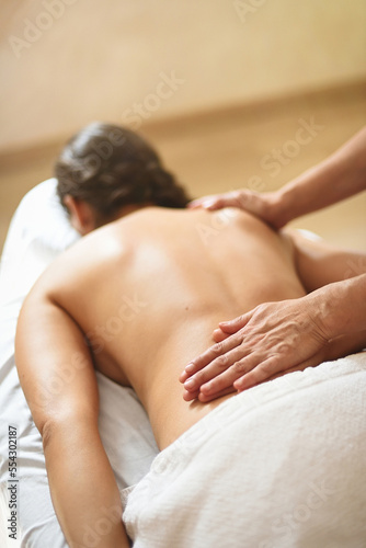 Woman lying face down receiving reiki energy and relaxing massage session