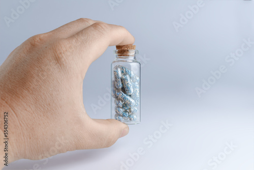 Glass jar with a tablet in the hand on a blue background