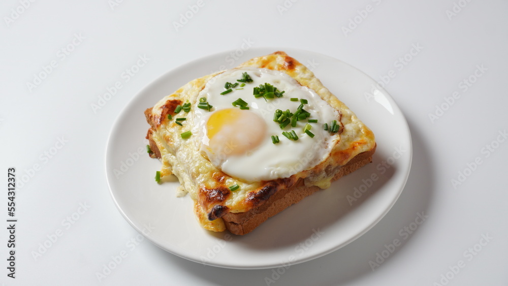 Hot French Traditional Croque madame sandwich for breakfast. Melted cheese and a fried egg on the top Hot French Traditional Croque madame sandwich for breakfast. Melted cheese and a fried egg on the top