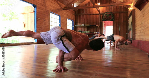 Yogi instructor teaching students advanced Yoga asana pose