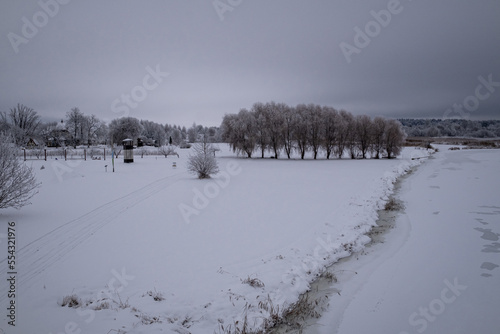 winter landscape taken from bridge over Vircava river near Jelgava town in Latvia. Bypass road to Riga. Snow and ice covered river in Latvia. Gloomy overcast winter morning