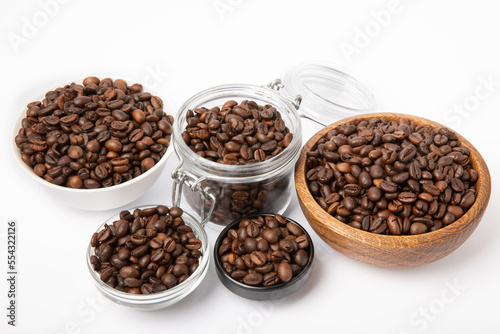 Bowls and jars with coffee beans isolated on white background.