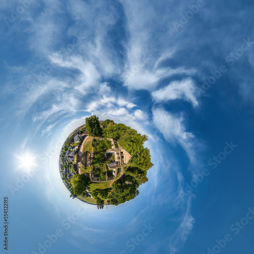 Fototapeta Naklejka Na Ścianę i Meble -  green tiny planet in blue sky with beautiful clouds with transformation of spherical panorama 360 degrees. Curvature of space.