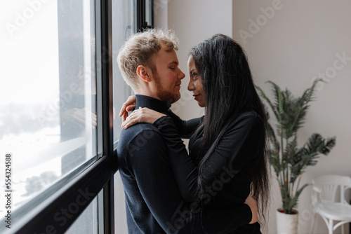 Couple in love tenderly hugs in a cozy home environment 