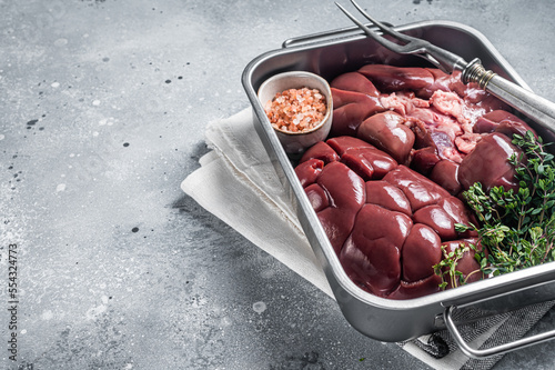 Fresh Raw Beef veal kidney in kitchen tray. Gray background. Top view. Copy space photo
