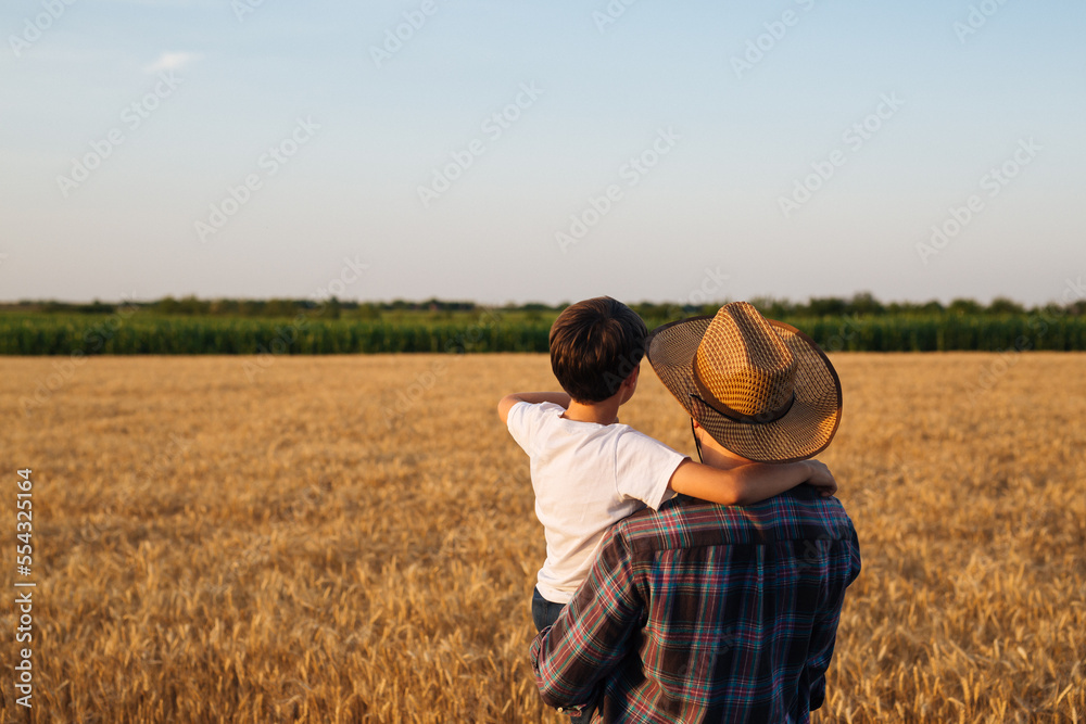 Father and son looking at their wheat field together Father and son looking at their wheat field together