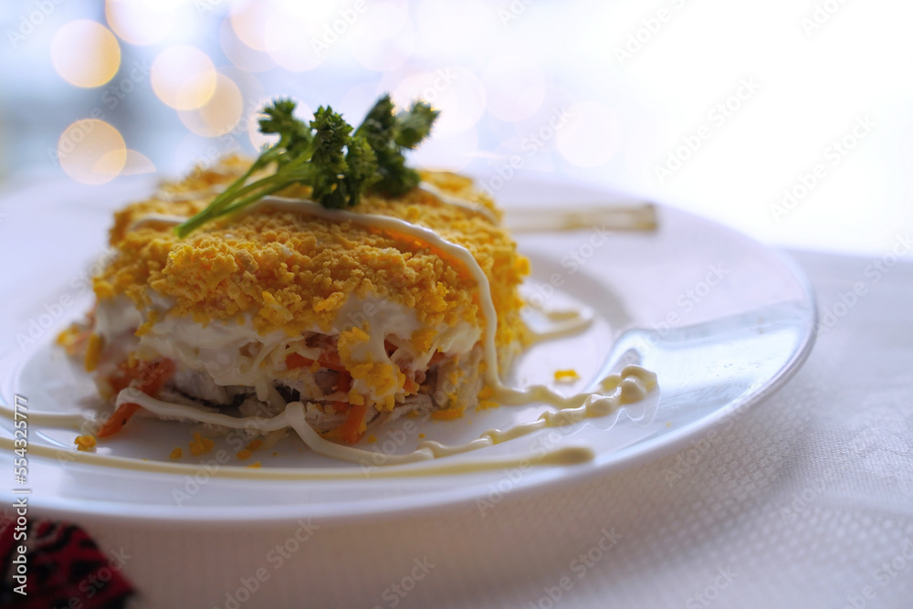 Homemade mimosa salad. Traditional Ukrainian food on the table with embroidered tablecloth.