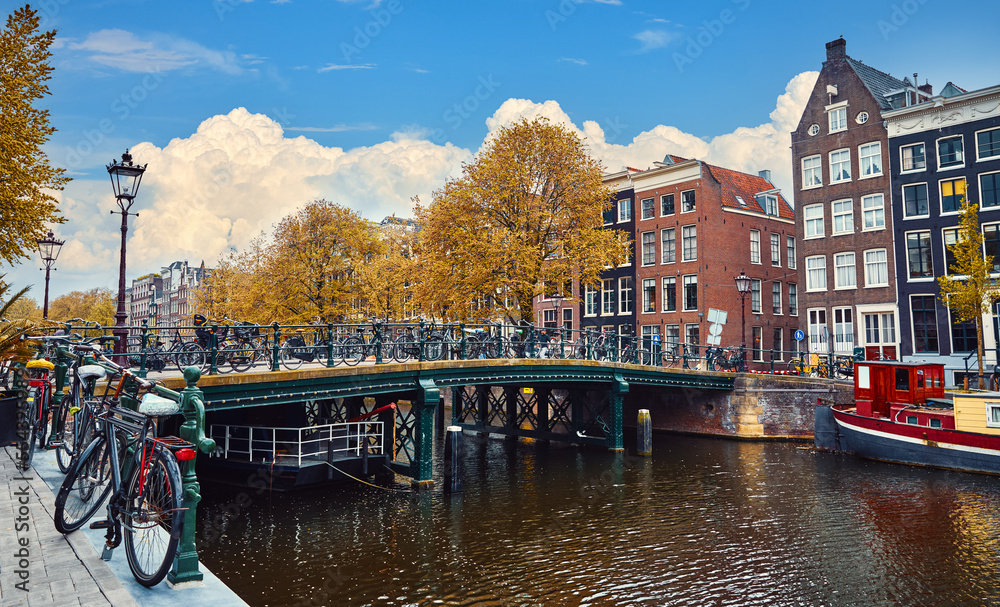 Channel in Amsterdam Netherlands Holland houses under river Amstel. Landmark old european city spring landscape with sunshine
