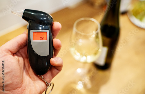 Man holds an alcohol tester in his hand.