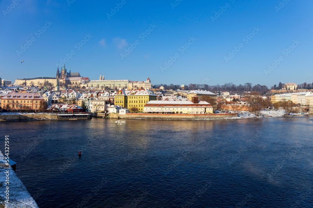 Sunny snowy Prague Lesser Town with gothic Castle from Charles Bridge, Czech republic