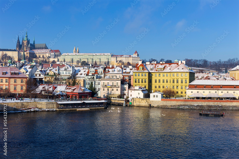 Sunny snowy Prague Lesser Town with gothic Castle from Charles Bridge, Czech republic