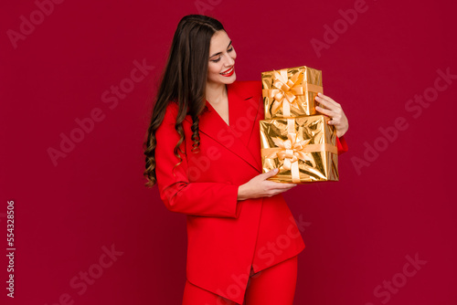 attractive woman celebrating Christmas on red background © mary_markevich