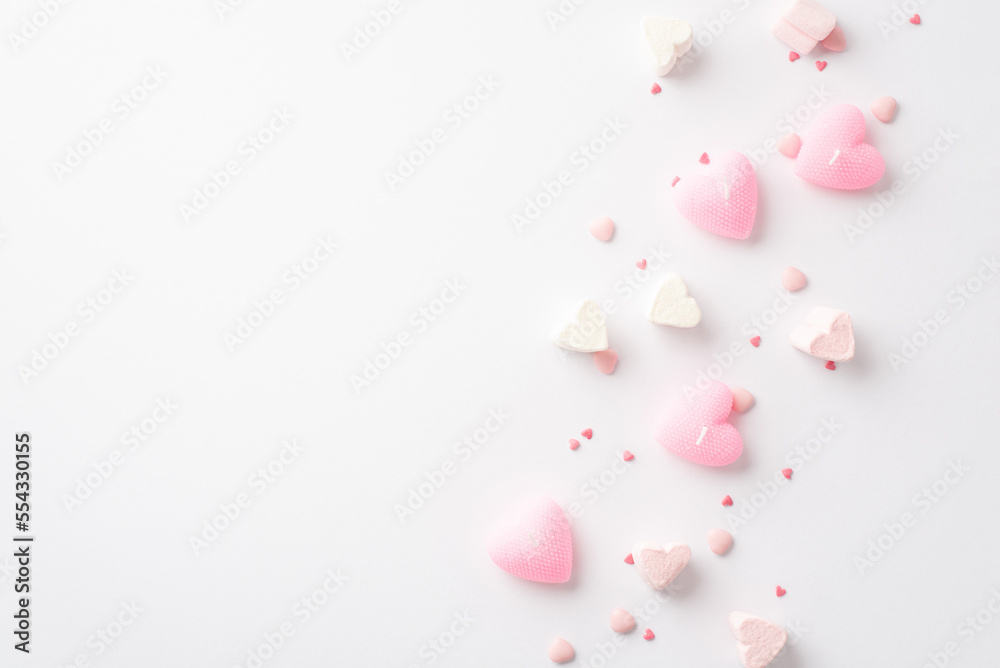 Valentine's Day concept. Top view photo of heart shaped candles marshmallow and sprinkles on isolated white background with empty space