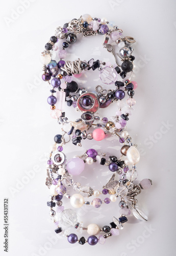 different stylish jewelry bracelets with semiprecious  around  white background. hobby and fashion concept. top view photo