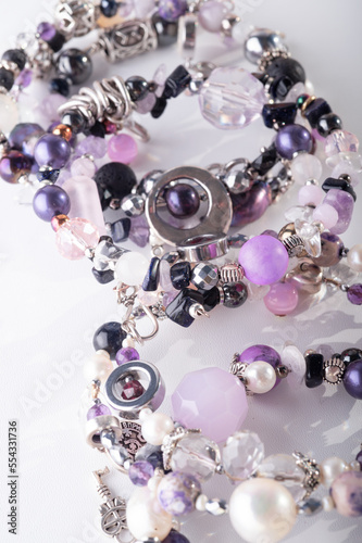 different stylish jewelry bracelets with semiprecious  around  white background. hobby and fashion concept. close up photo