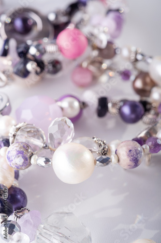 different stylish jewelry bracelets with semiprecious  around  white background. hobby and fashion concept. macro shot photo