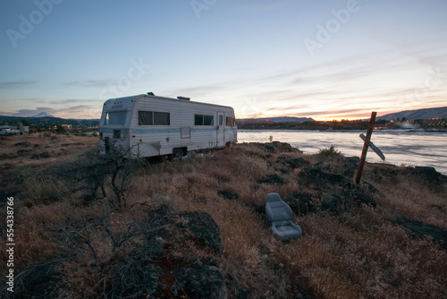 A recreational vehicle parked on the bank of the Columbia River across from The Dalles dam.; Columbia River, The Dalles, Oregon