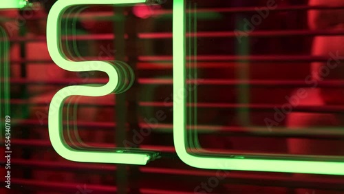 Neon Glowing Hotel, hostel neon green color sign with fluorescent light glowing on the window stall. Text hotel by neon lights sign.