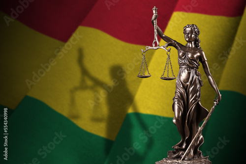 Bolivia flag with statue of lady justice and judicial scales in dark room. Concept of judgement and punishment, background for jury topics photo