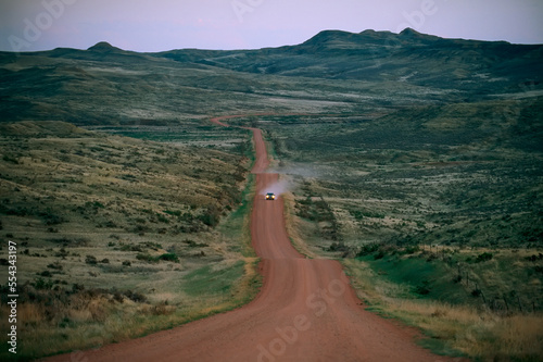 A truck travels along a dirt road in the sagebrush country of Wyoming, USA; Gillette, Wyoming, United States of America photo