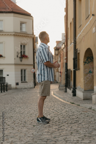 Obraz na płótnie A middle-aged male tourist is looking at the sights in an old European town w salonie