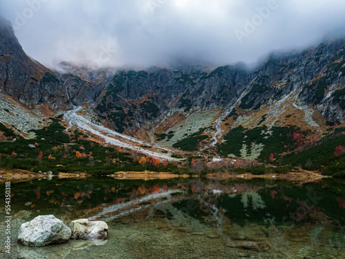 Rock and reflections in a mountain lake autumn