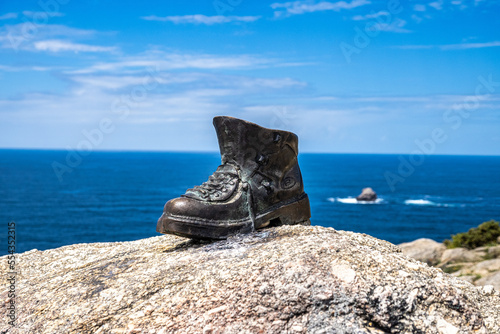 Used boots shoes at the end of Saint James Way in Finisterre Fisterra Camino de Santiago Spain photo