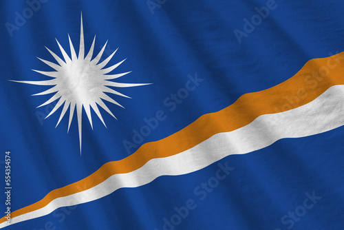 Marshall Islands flag with big folds waving close up under the studio light indoors. The official symbols and colors in fabric banner photo