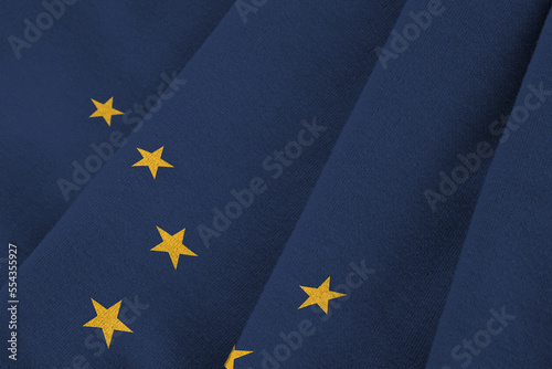 Alaska US state flag with big folds waving close up under the studio light indoors. The official symbols and colors in fabric banner photo