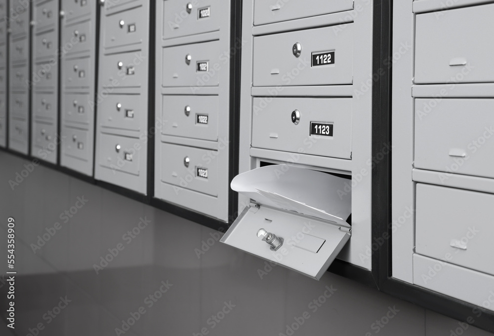 Open grey metal mailbox with envelopes indoors Open grey metal mailbox with envelopes indoors