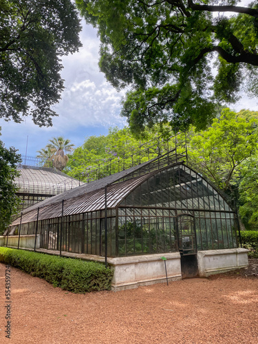 Botanical glass greenhouse in the park in summer