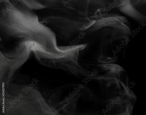 White puffs of smoke on a black background float mixing in bizarre chaotic patterns of thin threads