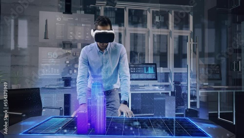 Professional Male Architect wearing Augmented Reality Headset makes gestures and redesigns 3D City Model. High Tech Office use Virtual Reality Modeling Software Application. photo