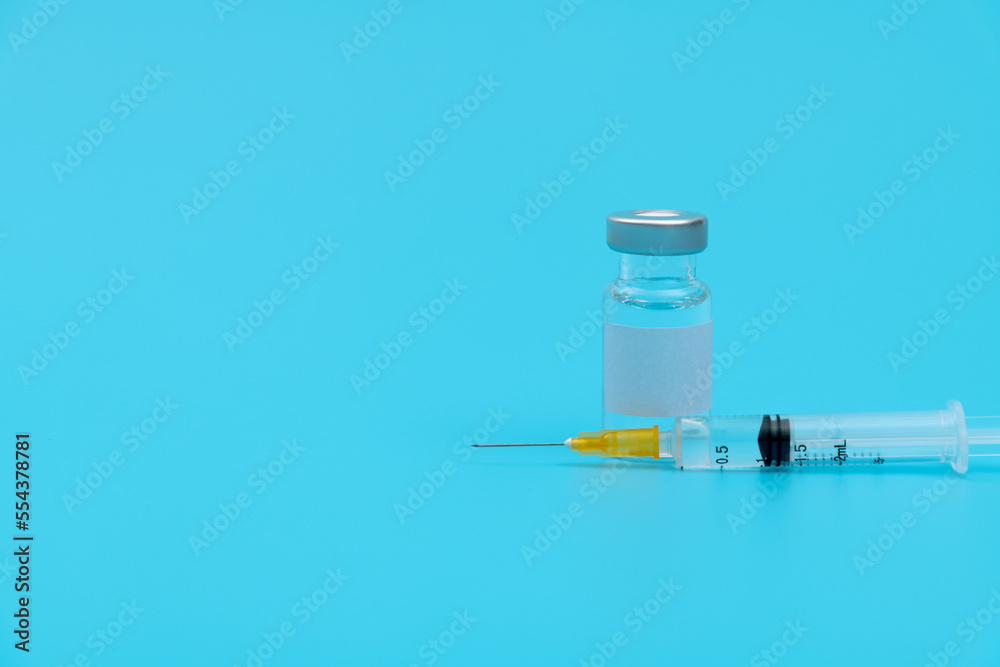 Syringe and vaccine on blue background Syringe and vaccine on blue background